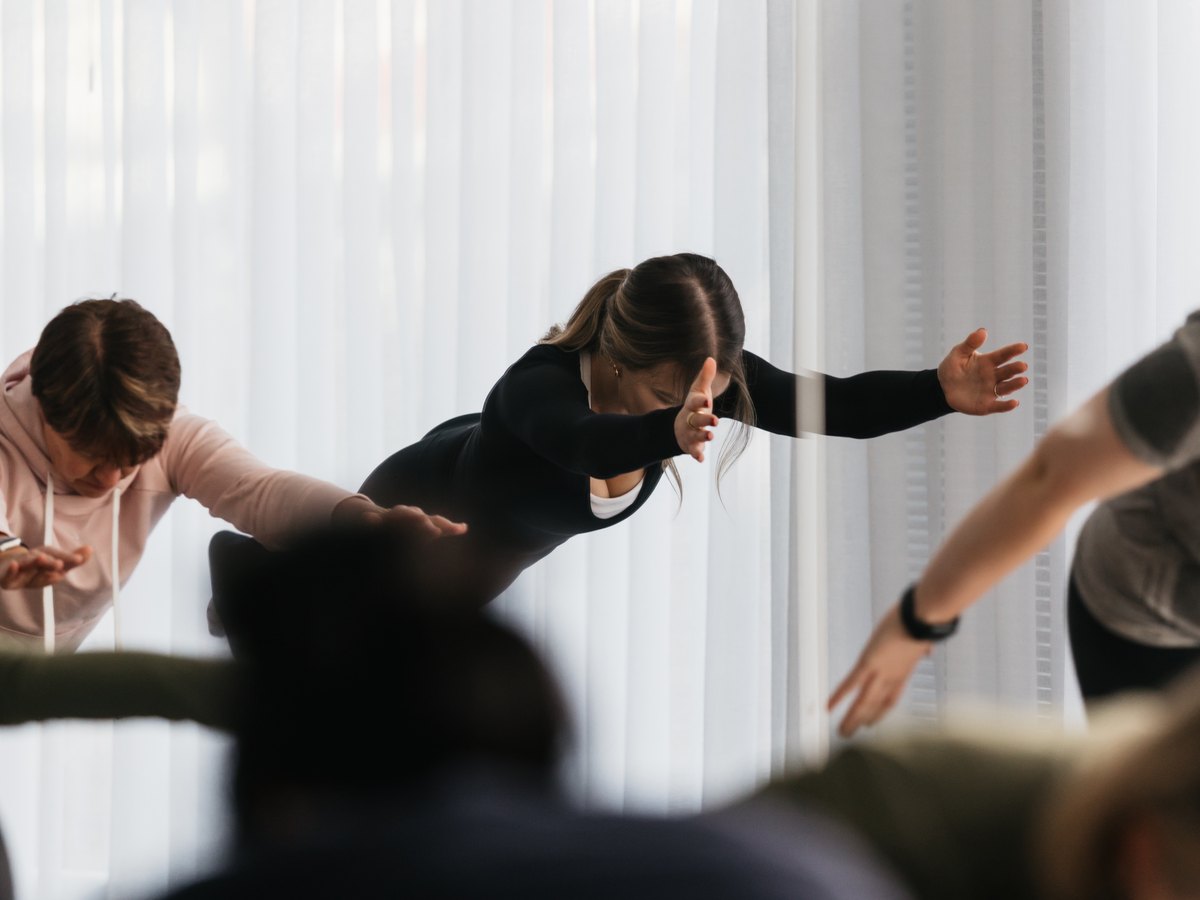 A yoga class moving through a flow in the SiSU mat studio