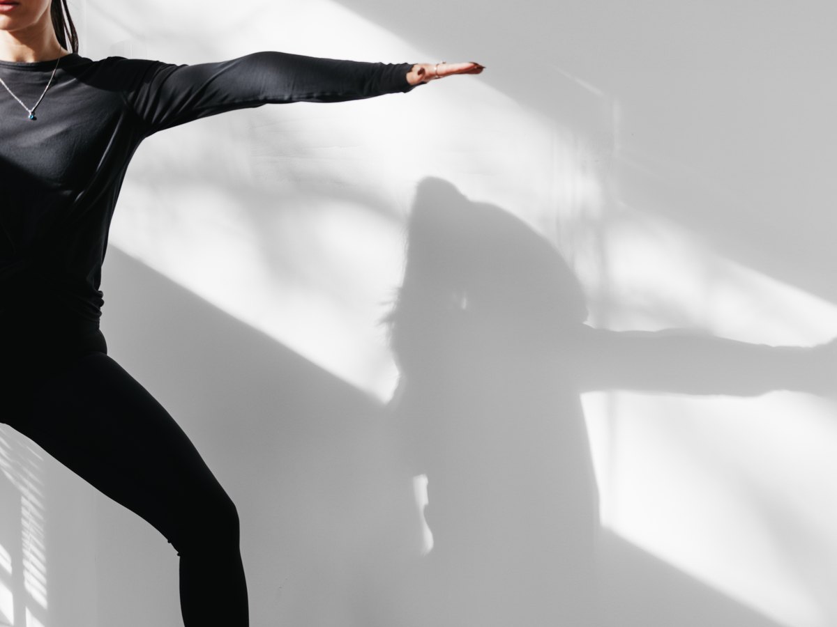 A standing pose and its shadow on the wall of the SiSU mat studio